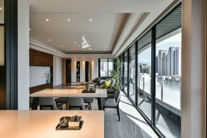 A modern living room featuring glass and marble finishes.
