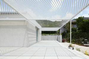 Modern exterior with metal roof and white tile patio.