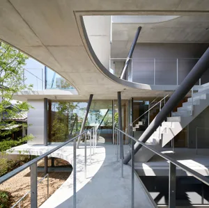 A minimalist indoor setting featuring concrete structures and open spaces.