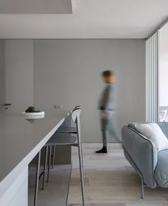 A modern minimalist living room with a concrete floor and wall.