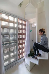 A modern residential stairwell with concrete steps and a glass wall.