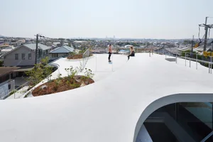 Cyclist riding circular ramp on white concrete rooftop