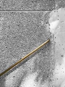 A brass pipe embedded in a concrete floor.