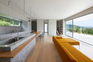 A contemporary residential living room featuring marble countertops, wooden flooring, and glass elements.