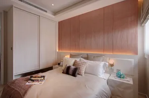 A minimalist bedroom featuring a white bed with a wooden headboard and white furniture.