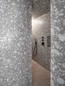 Modern bathroom with white and gray terrazzo wall tiles.