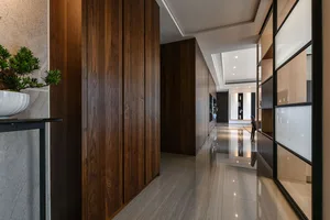 Modern contemporary corridor with wooden paneled walls and reflective floor tiles.