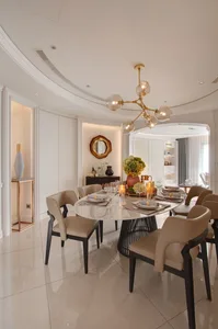 Modern dining room with marble table, leather chairs, and metal accents