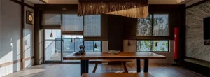 Modern dining room with wooden furniture, large windows, and open layout.