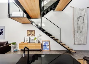 A modern living room featuring a floating staircase made of wood.