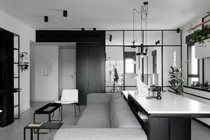A modern minimalist living room with a grey sofa, black accents, and white marble countertops.