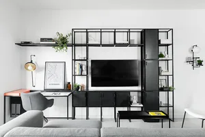 Modern minimalist living room featuring black metal furniture, white walls, and a flat-screen TV.