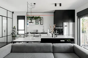 A modern residential kitchen featuring dark accents, clean lines, and a minimalist design.