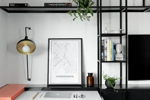 A modern minimalist workspace featuring a black and white color scheme with metal shelving, a white desk, and various office 