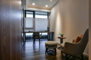 A modern minimalist living room featuring wooden furniture and fabric upholstery.