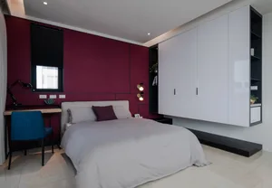 Contemporary bedroom with a monochromatic color scheme featuring a upholstered bed, floating nightstands, and sleek, modern f