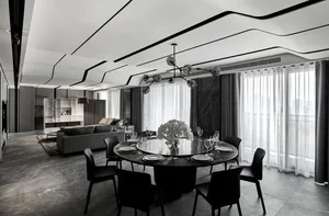 Modern living and dining room with metallic black and white color palette, featuring a circular dining table.