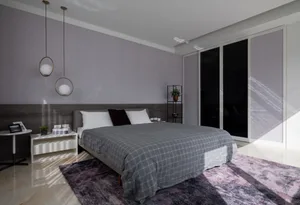 Minimalist bedroom, featuring a gray textile bedspread, modern lighting, and a wooden headboard, with a carpet, a potted plan