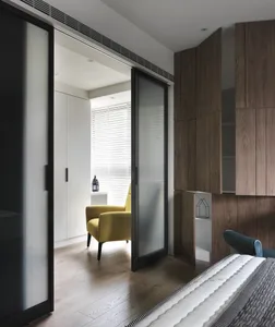 A modern minimalist bedroom with wooden furniture and white walls.