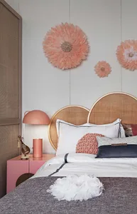 Modern bedroom with a cane headboard and wallflowers.