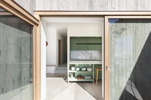Modern green kitchen featuring minimalist design and concrete construction.