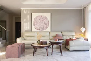 Modern living room with leather sofa and coffee tables.