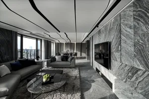 A modern living room featuring a marble wall, ceiling details, and a grey sofa with a marble coffee table.