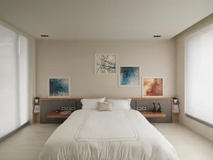 Modern minimalist bedroom with a white bed, white bedding, and abstract paintings on the wall.