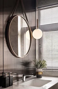 Modern bathroom with metal-textured wall and circular mirror above sink.