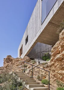 Modern residential house with concrete exterior on a rocky cliffside