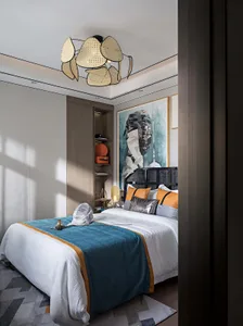 A bedroom with a modern design featuring textile bedding, metal frames, and wood elements.