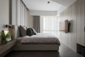 Minimalist bedroom with light gray and beige color palette, featuring a plush bed with soft pillows, a sleek nightstand, and 