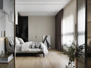 A modern minimalist bedroom with wooden flooring and a bed.