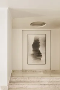 A minimalist abstract painting displayed on a light-colored, marble staircase, featuring geometric shapes and monochromatic t