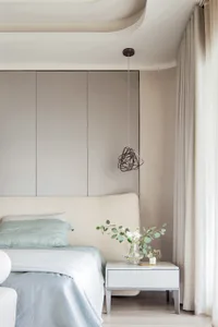 Modern minimalist bedroom featuring fabric, metallic, and glass elements.