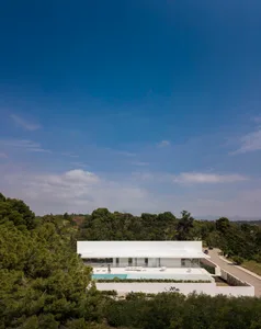 A modern residential exterior featuring concrete, glass, and steel materials.
