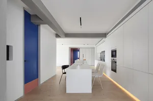 A modern, minimalist kitchen with white cabinets and accents.