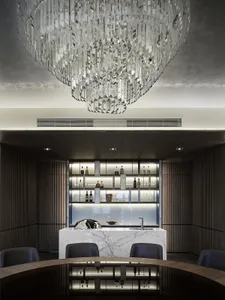 Modern dining room with a bar area showcasing marble countertops and a luxurious chandelier.
