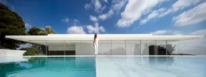 A modern house featuring extensive glass windows and a minimalist design.