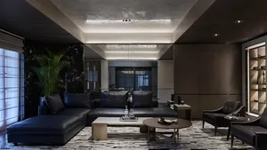 A modern living room featuring leather sofas, marble accents, and wooden furniture.