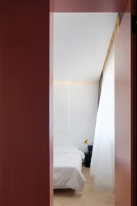 Modern minimalist bedroom with vertical space utilization, white bedding, and minimalistic design.