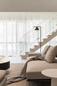 Modern living room featuring soft, neutral furnishings with a minimalist design.
