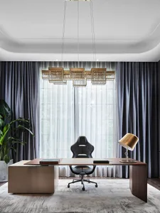 A modern office space featuring minimalist design with wooden desk, leather office chair, and glass windows with gray curtain