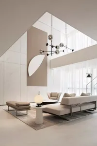 A modern living room featuring minimalist furniture, fabric upholstery, and geometric light fixtures.