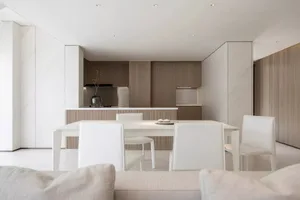 A modern residential kitchen featuring marble countertops and wooden cabinets.