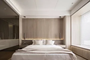 A serene modern bedroom featuring a bed with neutral-toned bedding and a wood-paneled headboard, viewed from a slightly eleva