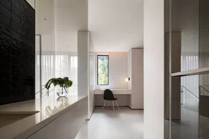 Minimalist office space featuring a glass wall and simple furnishings.