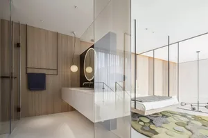 Modern minimalist bedroom featuring a wooden-paneled wall, white furniture, and a circular mirror with wooden frame.