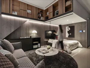 Modern living room featuring a sofa, coffee table, television, and shelving unit with lighting.