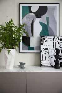 A modern interior design featuring contemporary furniture and materials, including abstract art, geometric shapes, and a pott